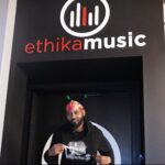 Flyboi Rich wearing a black hoodie and colorful head covering